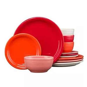 A collection of colorful dinnerware, including various plates and bowls in shades of red, orange, and pink.