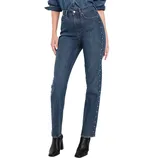 High-waisted blue jeans with button and rivet detailing down the sides, paired with a matching denim shirt and black ankle boots.