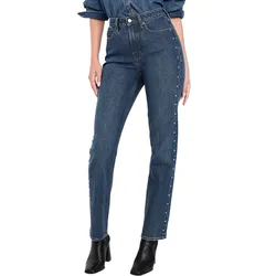 High-waisted blue jeans with button and rivet detailing down the sides, paired with a matching denim shirt and black ankle boots.