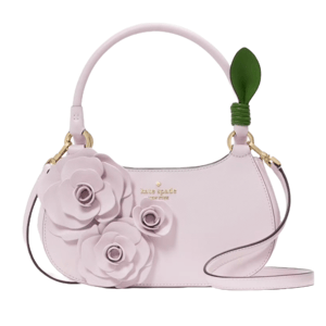 A pastel pink handbag with a top handle and floral embellishments, featuring a green leaf detail on the handle and gold accents.