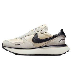 A beige and black Nike sneaker with a retro design, featuring a prominent black Swoosh and a thick white sole.