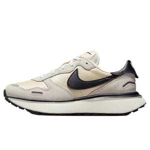 A beige and black Nike sneaker with a retro design, featuring a prominent black Swoosh and a thick white sole.