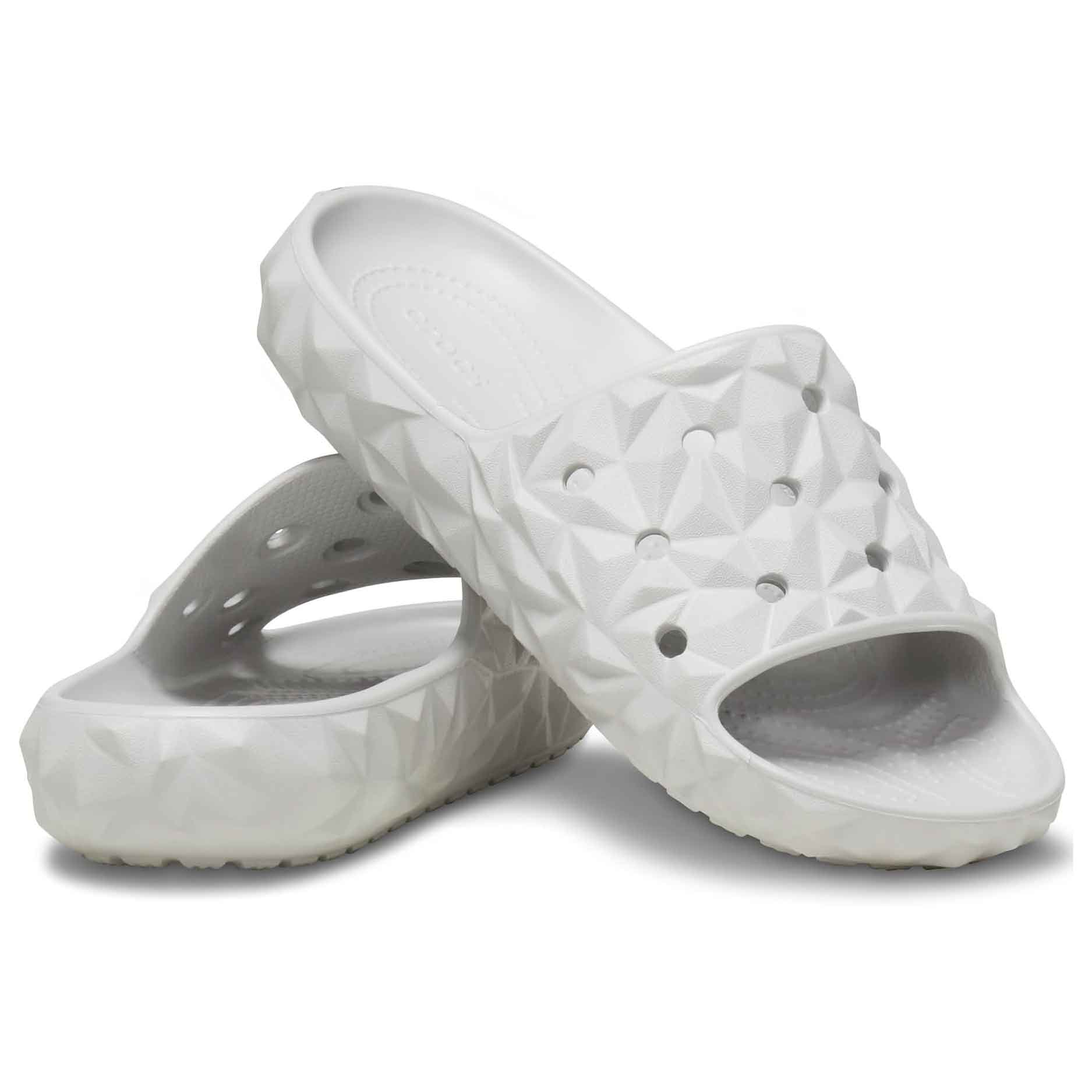 White geometric-patterned slide sandals with open toes, featuring breathable holes and textured soles for comfort and grip.
