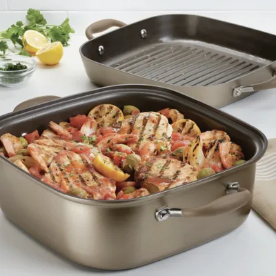A square-shaped cookware set includes a grill pan and a deep dish, featuring grilled chicken with lemons, olives, and tomatoes.