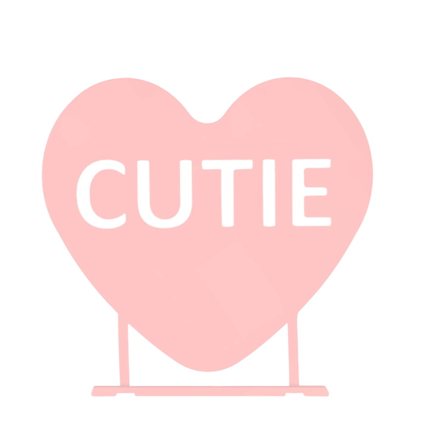 A pink heart-shaped sign featuring the word \“CUTIE.\“