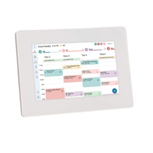 A digital calendar display stands on a kitchen counter, showing a family's weekly schedule with color-coded events and tasks, like a camping trip and appointments.