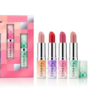 A set of five Clinique lipsticks in varying shades from nude to deep red, housed in metallic cases with multicolored bases, accompanied by a pink and multicolor box.