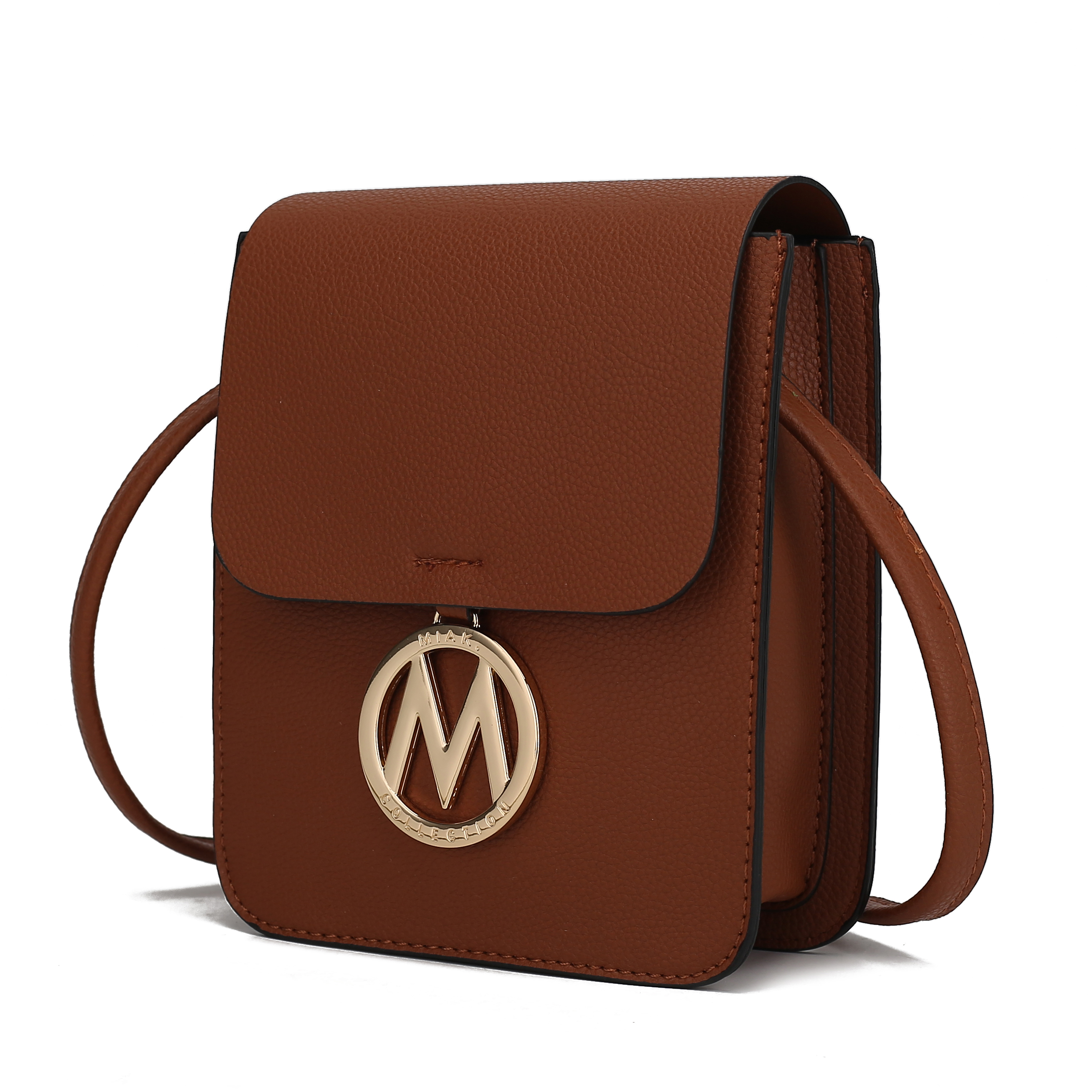 Brown leather crossbody bag with a flap closure and a gold circular emblem featuring the letter \“M\“ hanging on the front.