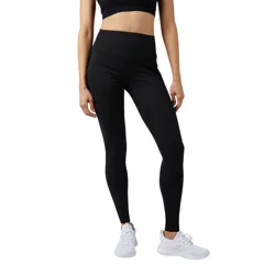 A person is wearing black high-waisted leggings and white athletic sneakers.