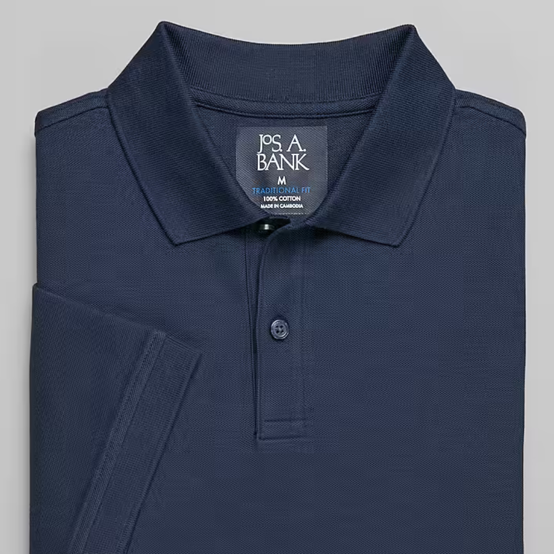 Navy blue polo shirt with a collar and a Jos A. Bank label indicating a medium traditional fit, made of 100% cotton.