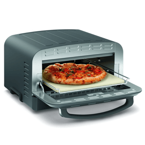 A countertop pizza oven with a pizza stone, shown baking a pizza with toppings like tomatoes and herbs.