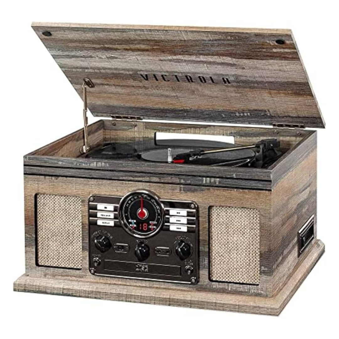 A vintage-style Victrola record player with built-in speakers and a radio tuner, featuring a wooden finish and control knobs on the front panel.