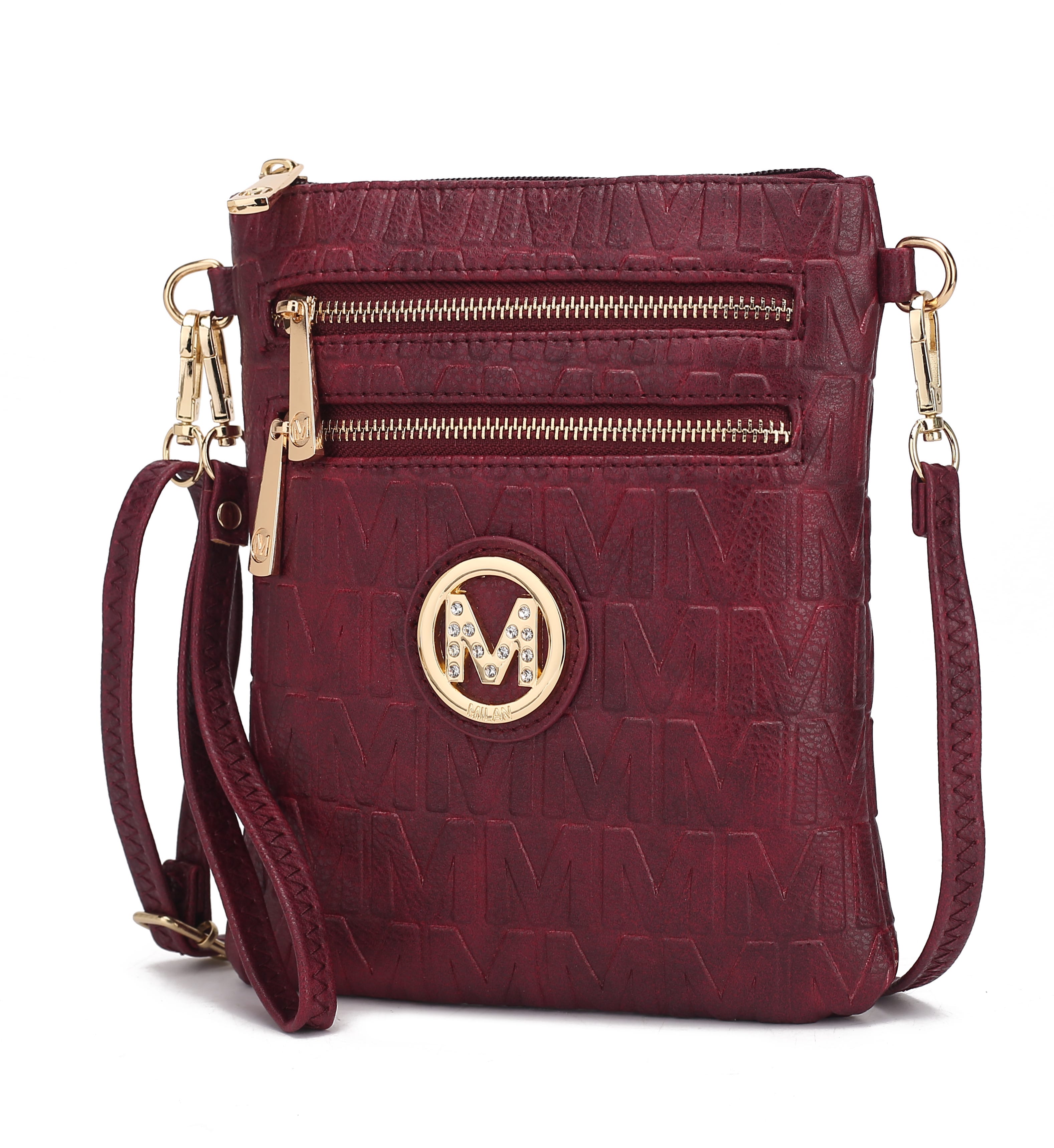 A maroon crossbody bag featuring an embossed \“M\“ pattern with gold accents, including two zip compartments and a circular emblem with rhinestones.