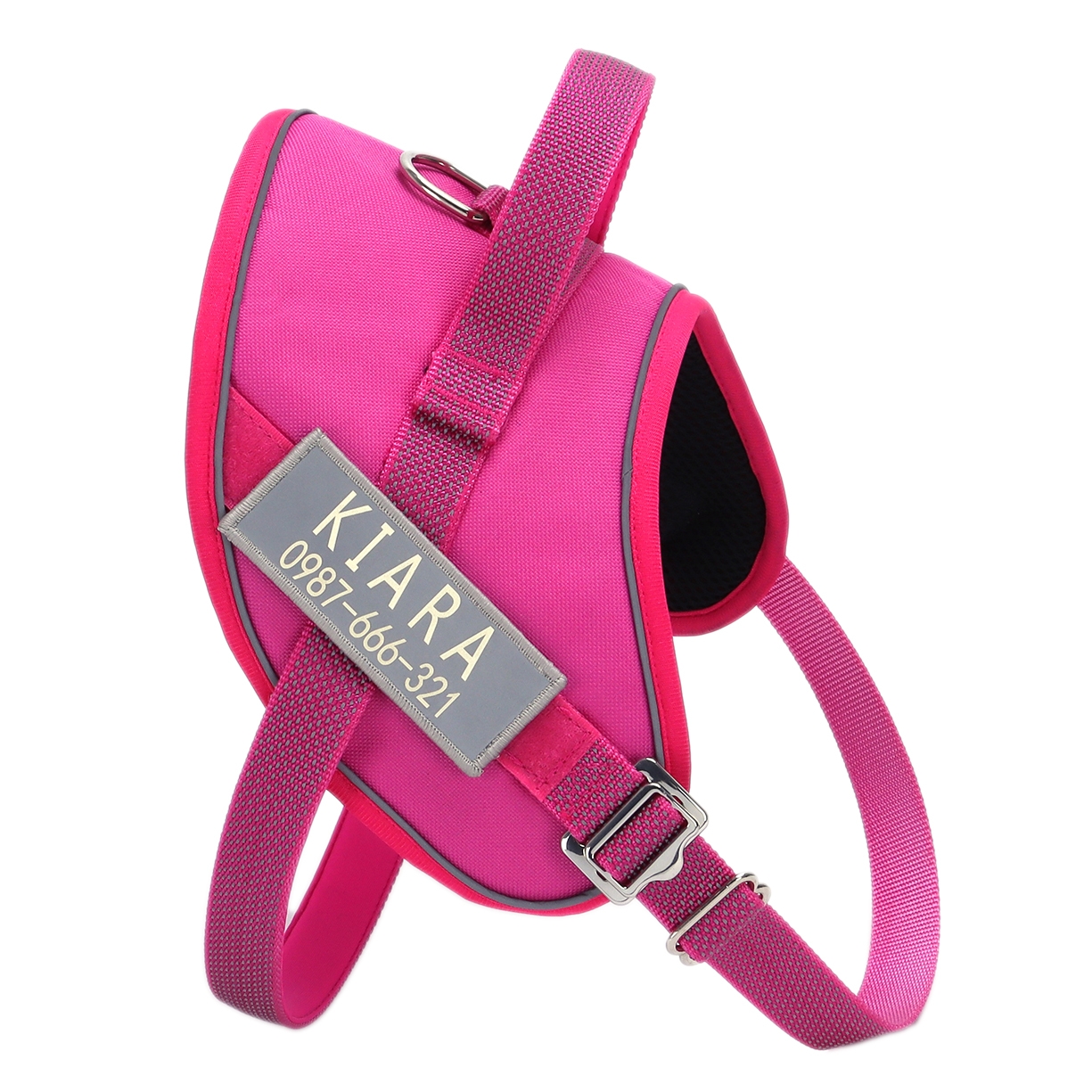 Bright pink dog harness with adjustable straps and a metal D-ring for leash attachment; features a custom name tag with \“KIARA\“ and phone number.