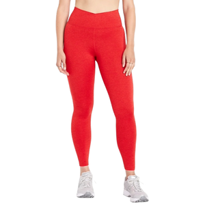 A person wearing high-waisted red leggings paired with white sneakers, showing a close-up of the lower body from the waist down.