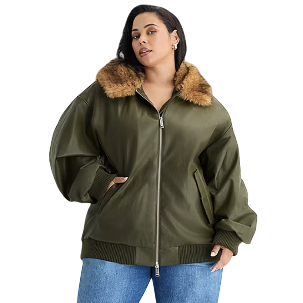A woman is wearing an olive green bomber jacket featuring a brown faux fur collar and ribbed cuffs, paired with blue jeans.