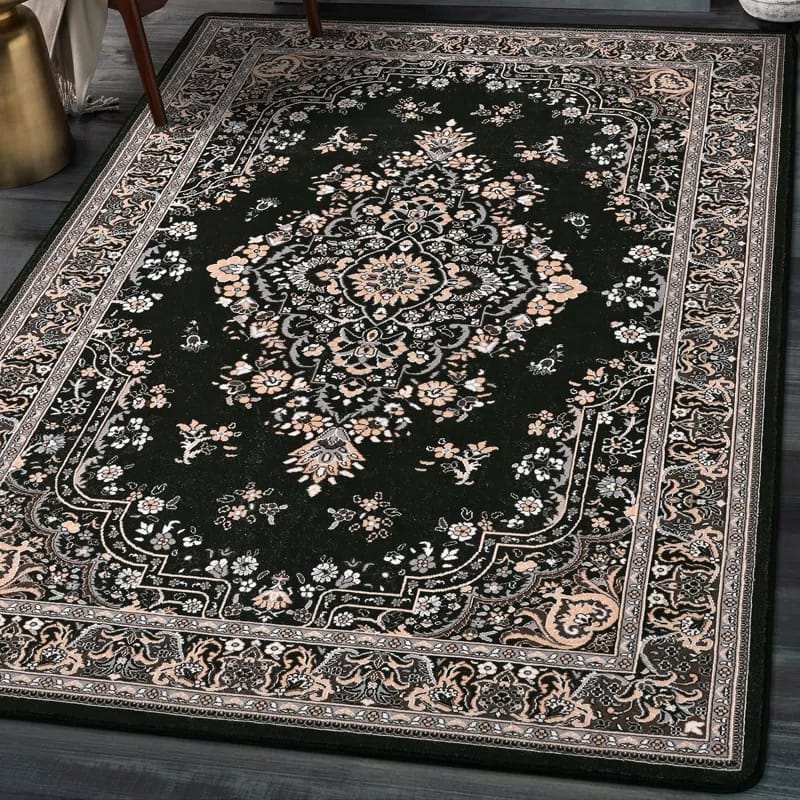 A dark green area rug with an intricate floral and medallion pattern, surrounded by a detailed border featuring similar floral motifs.