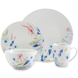 A floral porcelain dinnerware set with a plate, salad plate, bowl, and mug, each featuring a watercolor-style design with blue, pink, and green accents.