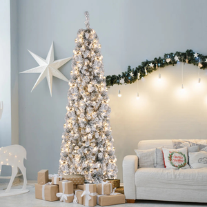 A tall, flocked Christmas tree with warm lights is surrounded by wrapped gifts. The room features a white star decoration, a garland with hanging lights, a white reindeer figure, and a beige couch with festive pillows.