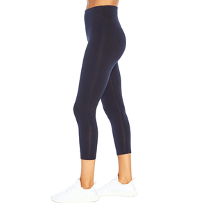 Black high-waisted leggings paired with white sneakers.