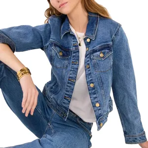 Denim jacket and jeans ensemble featuring gold button details, worn over a white t-shirt. The look is accessorized with gold bangles and a subtle necklace.