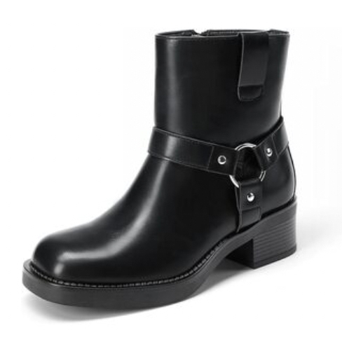 A black ankle boot with a low heel, featuring a decorative strap and metal ring detail.