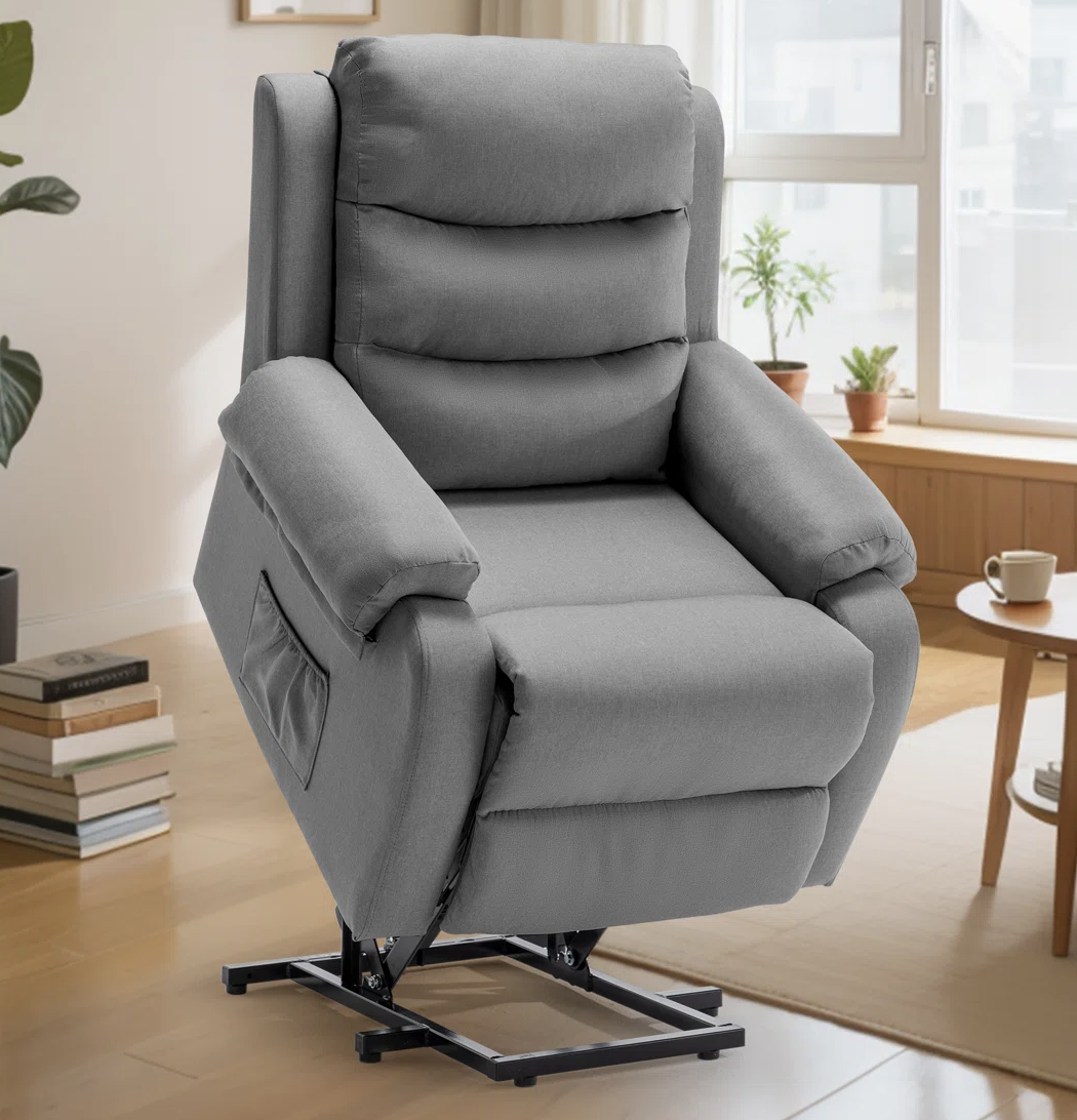 A gray reclining chair with a built-in lift mechanism, designed for assistance in standing up, features a pocket on the side and is set in a modern living room environment.
