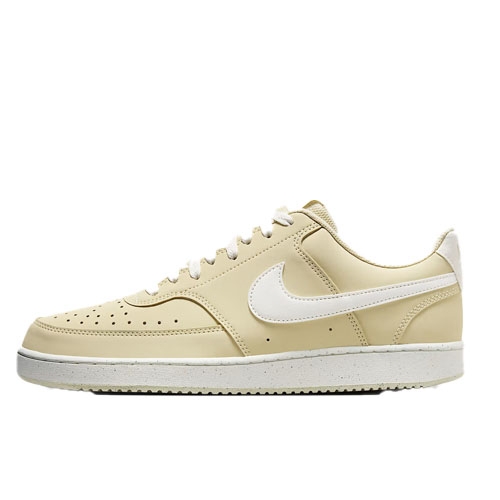 Cream-colored low-top sneaker with a white swoosh, perforated toe box, and white sole.