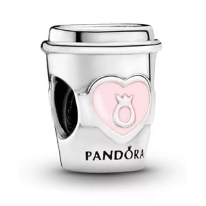 A Pandora charm shaped like a to-go coffee cup features a pink heart design with a ring icon and the Pandora logo engraved at the bottom.