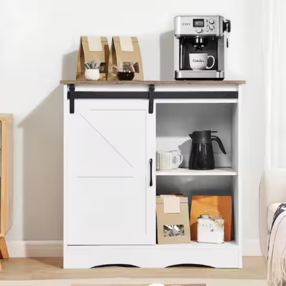 A white cabinet with a wooden top features a sliding door, revealing shelves holding coffee-related items. On top, a coffee machine is accompanied by paper bags and a potted plant.