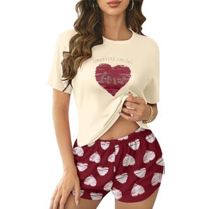 The women's pajamas feature a cream-colored T-shirt with \“Something special love\“ printed over a red heart and matching red shorts with white heart patterns.