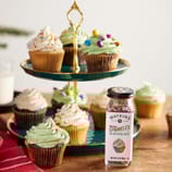 Watkins Dye-Free Rainbow Sprinkles come in a 3.4 oz (98 g) bottle and feature colorful sprinkles without artificial dyes, suitable for decorating baked goods like cupcakes.