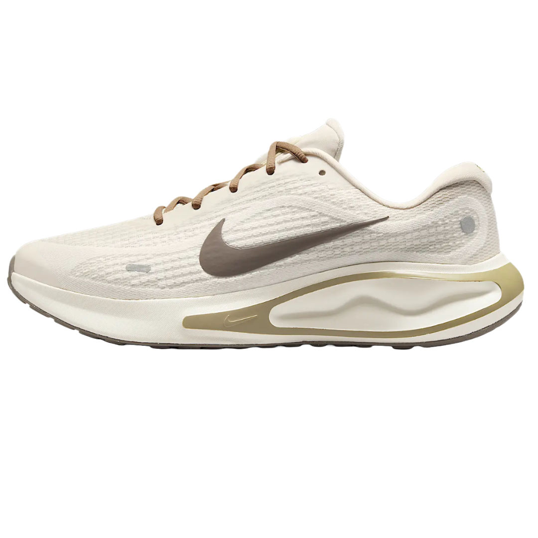 Nike Men's Journey Run Shoes feature a sleek, lightweight design with a beige upper, brown laces, and a brown Swoosh logo. They have a cushioned midsole for comfort and a stylish, modern aesthetic.