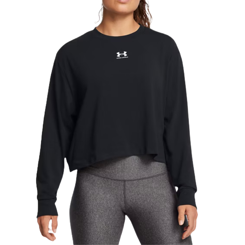 Under Armour Rival Boxy Long Sleeve is a black, loose-fitting top with a relaxed, cropped silhouette and long sleeves, featuring the Under Armour logo on the chest. It's paired with gray, form-fitting leggings.
