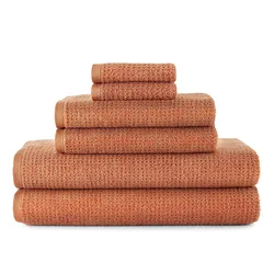 Stack of terracotta-colored towels, including bath towels, hand towels, and washcloths, neatly arranged by size.