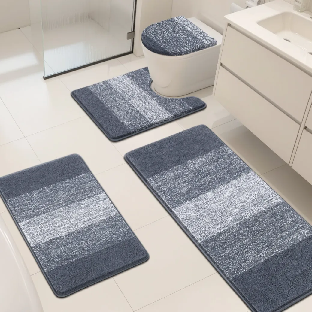 Four blue and gray striped bath mats, including a toilet seat cover, are arranged on a white bathroom floor.