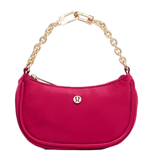 A small pink handbag with a gold chain strap, featuring a logo on the front.