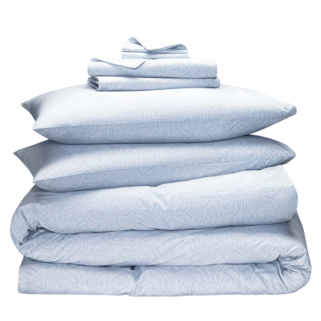 A neatly stacked blue bedding set featuring a duvet cover, sheet set, and multiple pillowcases with a subtle line pattern.