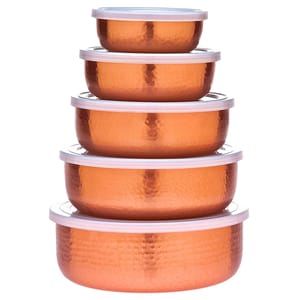 A stack of five copper-colored, hammered metal nesting bowls with white lids, arranged in decreasing size order.