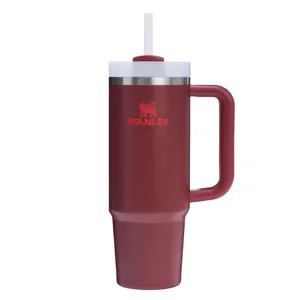 A red Stanley insulated tumbler featuring a handle and straw.