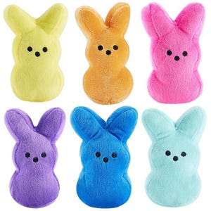 Set of six plush toys in the shape of Peeps bunnies, each featuring a different color: yellow, orange, pink, purple, blue, and light blue, with black eyes and nose detailing.
