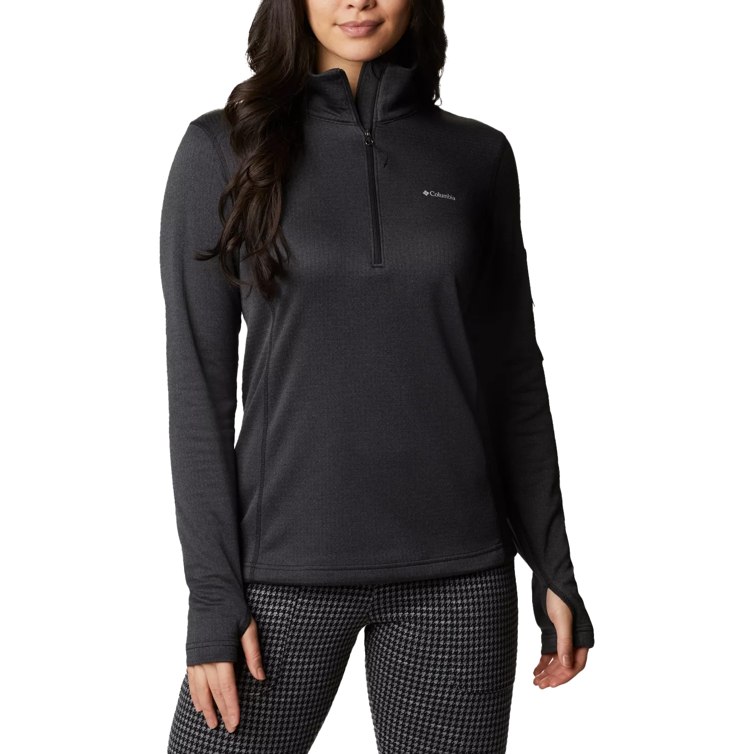 A woman is wearing a dark long-sleeve, half-zip Columbia pullover with thumbholes and patterned leggings.