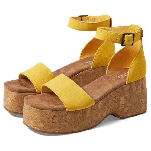 A pair of sandals with a tan heel and yellow straps.