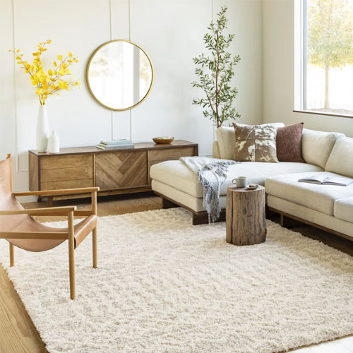 a tan woven rug underneath a white sectional sofa