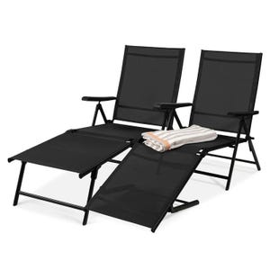 Two black reclining outdoor lounge chairs with adjustable footrests are shown, along with a folded striped towel placed on one of the chairs.
