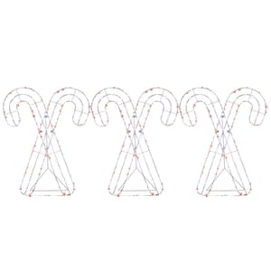 Three metal frames shaped like crossed candy canes decorated with string lights.