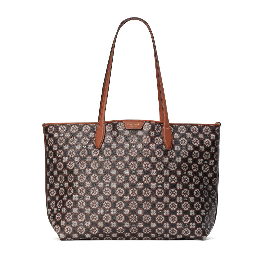 A patterned tote bag with brown leather handles and trim.