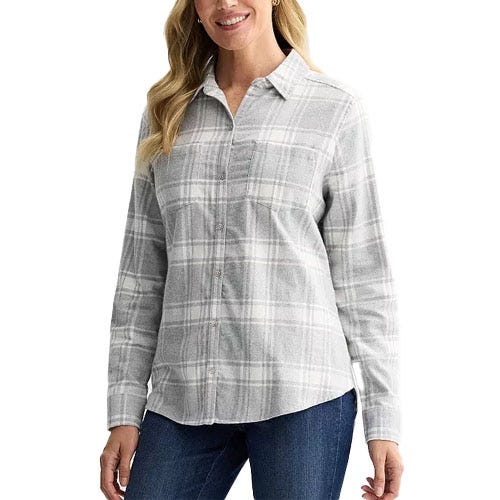 A woman is wearing a long-sleeve, gray plaid button-up shirt paired with blue jeans.