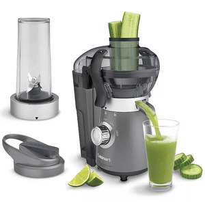 A Cuisinart blender and juice extractor with a sleek gray design, featuring a control dial with stop, low, and high settings. It is shown with a blending cup, lid, and a glass of green juice being poured, alongside sliced cucumbers and lime wedges.
