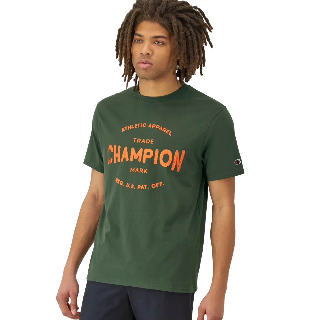 A person wears a dark green t-shirt with \“CHAMPION ATHLETIC APPAREL\“ printed in orange and a small logo on the sleeve.